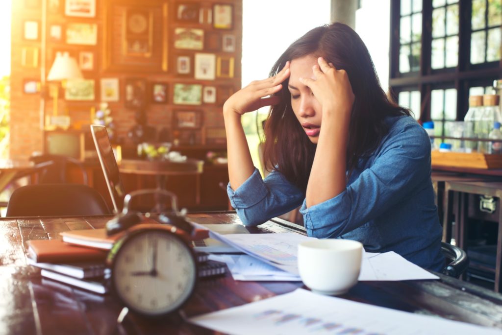 A frustrated woman stares at papers on her desk